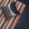 Navy and burnt sienna diamond pattern throw, paired with a navy striped cushion.